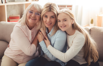 blonde Daughter Mom And Granny are sitting on the sofa